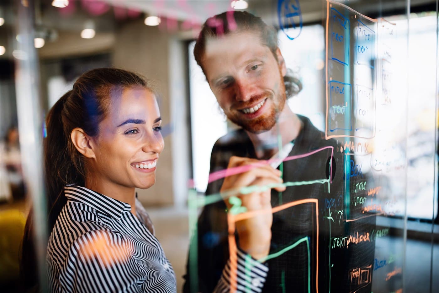 Colleagues collaborating on a glass board